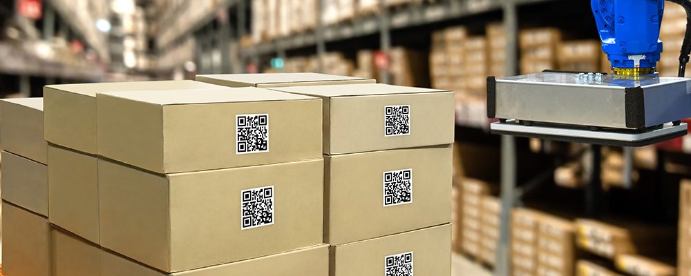 Smart logistic industry 4.0 , QR Codes Asset warehouse and inventory management supply chain technology concept. Group of boxes and Automation robot arm machine in storehouse