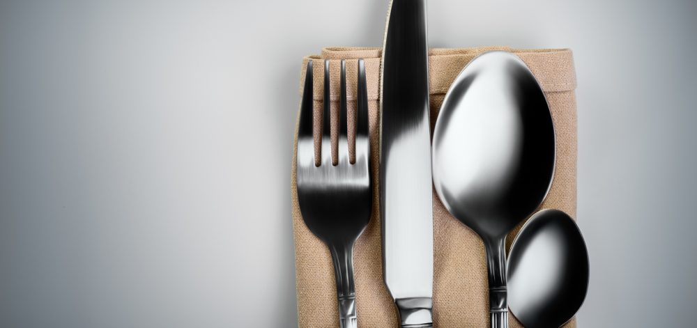 Shooting in the Studio .Fork,spoon,knife and small spoon wrapped in light brown cloth ,light background, etc.The view from the top.