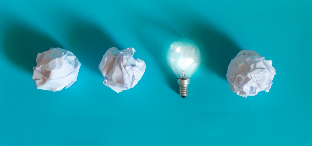 Concept of bright idea with paper and light bulbs. Business creativity, leadership concept.