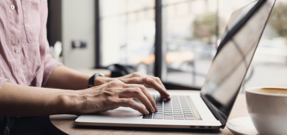 Woman working on laptop computer, female hands typing keyboard c